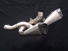गैलरी व्यूवर में इमेज लोड करें, A polished stainless steel motorcycle exhaust muffler with a black and silver triangular badge, shown against a black fabric background.